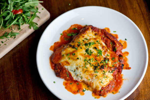Chicken parmigiana Traditional Italian comfort dish. Chicken breast covered in breadcrumbs lightly fried, topped with homemade marinara, melted mozzarella, parmigiana provolone and Italian parsley. stock photo