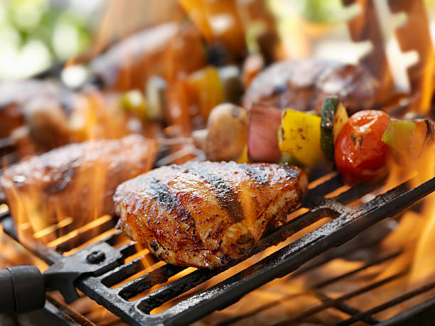 BBQ Chicken Chicken Thighs and Vegetable Kabobs on a Outdoor BBQ -Photographed on Hasselblad H3D2-39mb Camera chicken thigh meat stock pictures, royalty-free photos & images