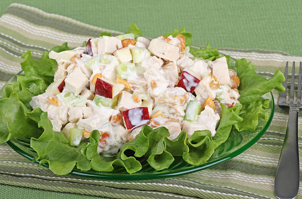 Chicken salad on a bed of greens Chicken salad with apple pieces on top of lettuce chicken salad stock pictures, royalty-free photos & images