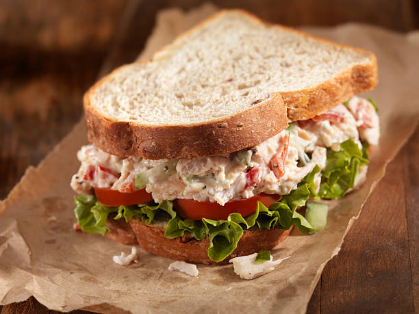 Chicken Salad Sandwich A Creamy Chicken Salad Sandwich with Red Peppers, Cucumber, Lettuce and Tomato on Whole Wheat Bread - Photographed on Hasselblad H3D2-39mb Camera chicken salad stock pictures, royalty-free photos & images