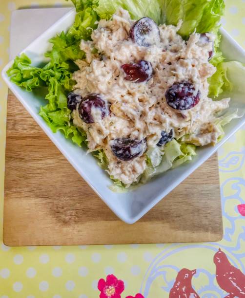 Chicken Salad with grapes and Nuts Homemade chicken salad made with chicken breast, red grapes, halved, cashew Nuts, mayonnaise, lemon juice, and salt and pepper, placed in a white bowl on top of leaf lettuce. chicken salad stock pictures, royalty-free photos & images
