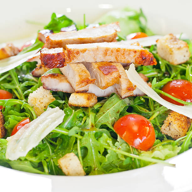 Chicken salad with tomatoes, arugula and bread croutons in the white...