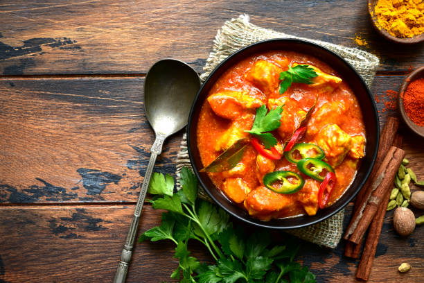 Chicken tikka masala - traditional dish of indian cuisine Chicken tikka masala - traditional dish of indian cuisine in a clay bowl over dark wooden background.Top view. curry powder stock pictures, royalty-free photos & images