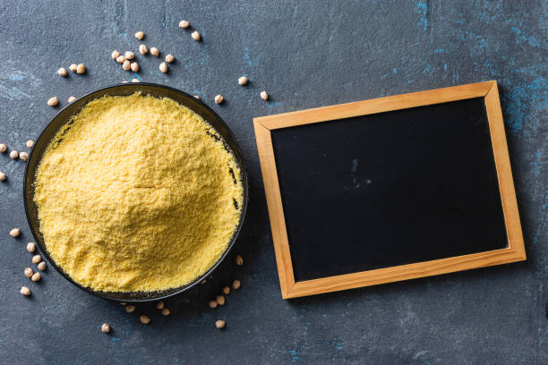 Chickpea flour in black ceramic bowl on dark background with empty chalkboard to place your text Chickpea flour in black ceramic bowl on dark background with empty chalkboard to place your text pea protein powder stock pictures, royalty-free photos & images