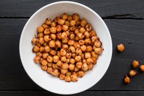 Chickpeas with spice in bowl on black background close up top view image stock photo
