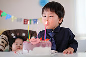 彼の誕生日ケーキのろうそくを吹き、彼の願いを作る子