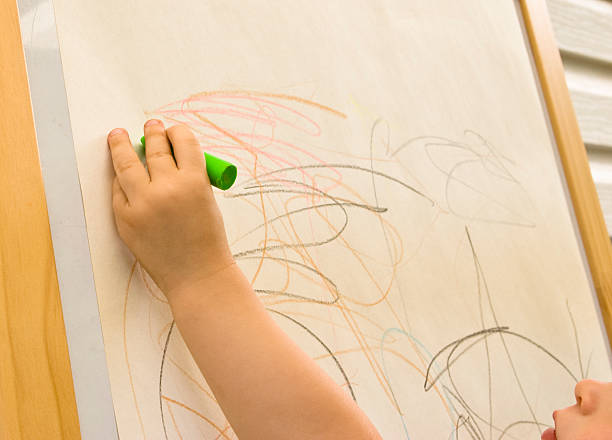 Child drawing with crayons stock photo