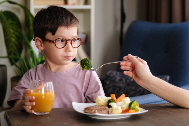 Child eating vegetables stock photo