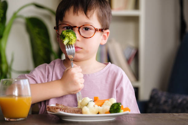 Child eating vegetables stock photo