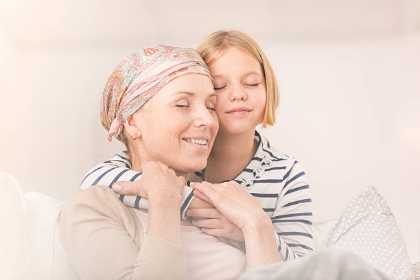 Child embracing ill mother stock photo