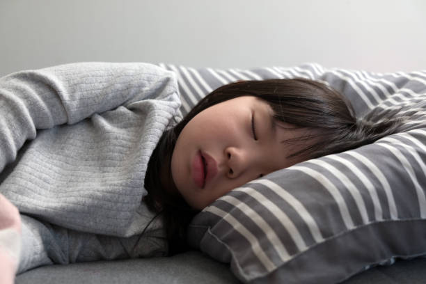 Child girl sleeping on bed stock photo