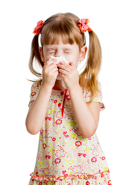 child girl wiping or cleaning nose with tissue isolated stock photo
