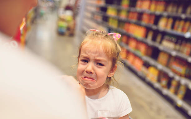 Child Having Arguement With Mother At Candy Counter stock photo