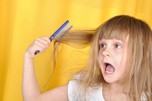 child having problem with brushing her hair stock photo