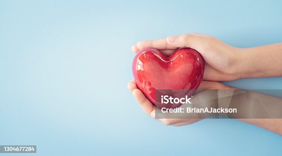 istock Child holding a red heart background 1304677284
