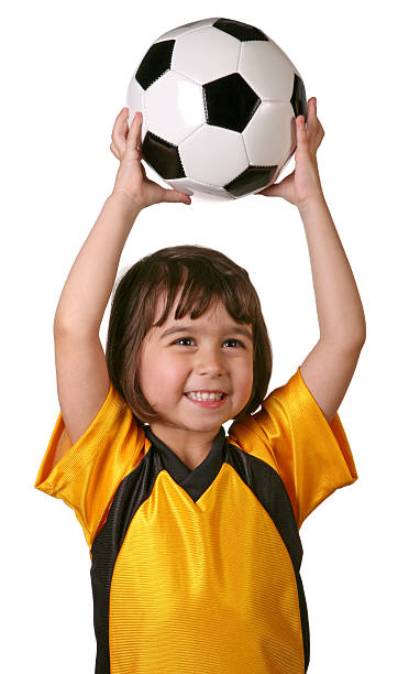 Child holding soccer ball above her head stock photo