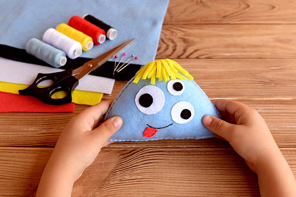 Child holds a felt monster in his hands stock photo