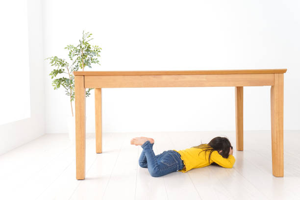 Child huddling under a table Child huddling under a table ugly girl stock pictures, royalty-free photos & images