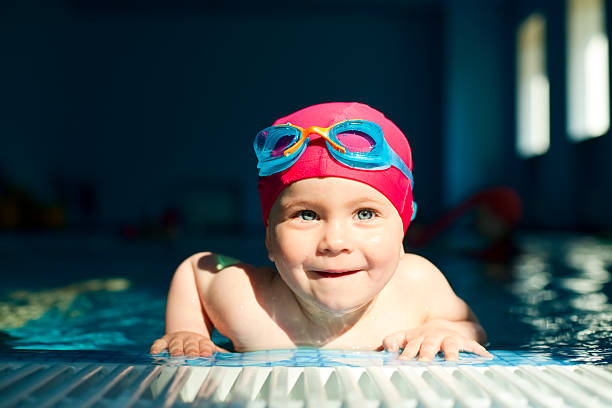 child in a swimming pool - swimming baby stockfoto's en -beelden