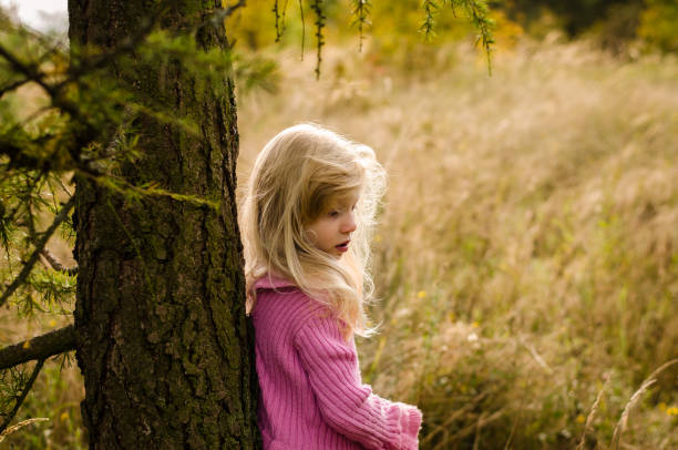 child in forest alone stock photo