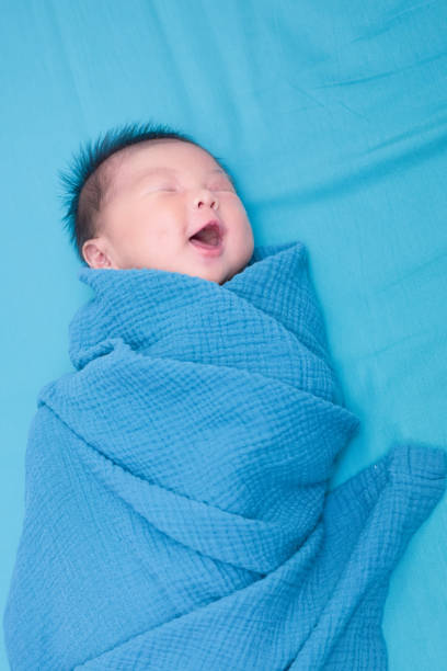 Child is laying in bed with laughing face stock photo