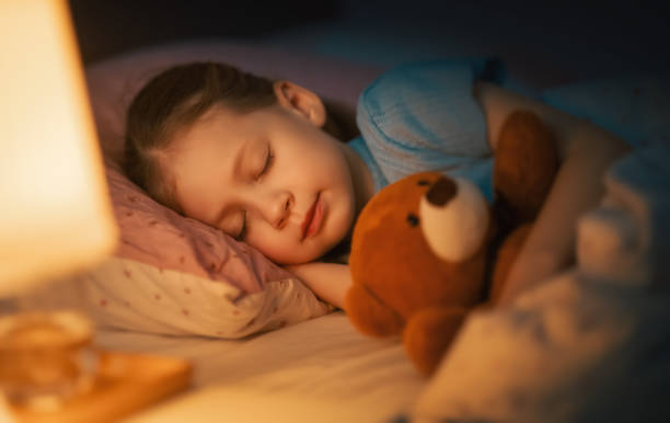 child is sleeping in the bed stock photo