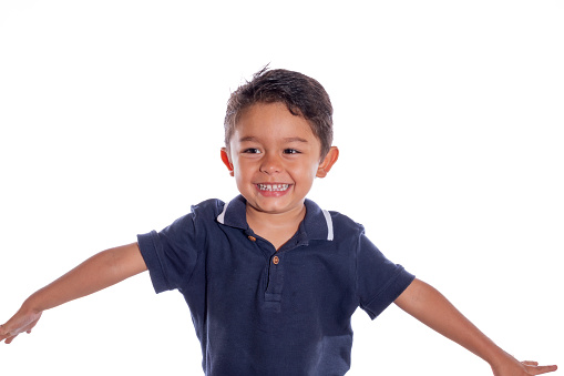 Child laughing. Beautiful latin boy laughing and opening his arms, isolated on white background.