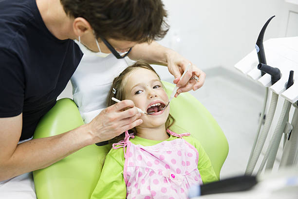 Child patient on her regular dental checkup Child patient in paediatric dentists office on her regular checkup for tooth decay, caries and gum disease. Early prevention, oral hygiene and milk teeth care concept. rotten teeth in children stock pictures, royalty-free photos & images