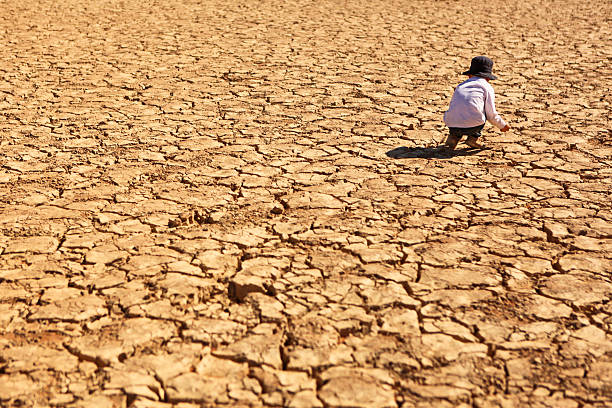 Child Playing on Dry Parched Desert Land stock photo