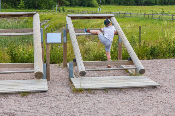 Child playing on outdoor gym on sunny summer day. Sweden. stock photo
