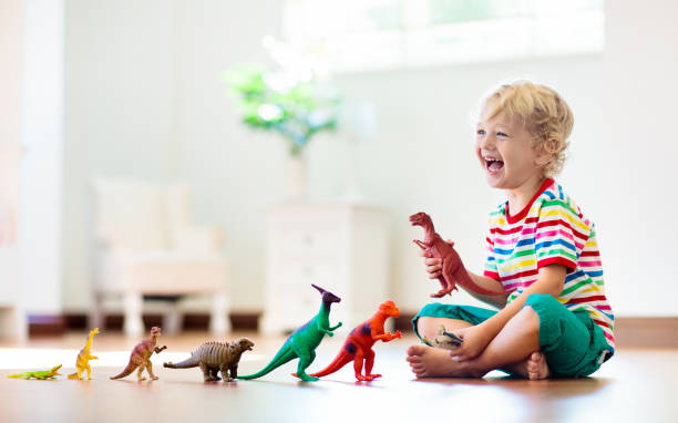 Child playing with toy dinosaurs. Kids toys. Child playing with colorful toy dinosaurs. Educational toys for kids. Little boy learning fossils and reptiles. Children play with dinosaur toys. Evolution and paleontology game for young kid. dragon photos stock pictures, royalty-free photos & images