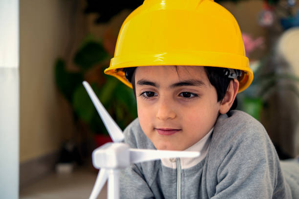 child plays at a wind turbine toy stock photo