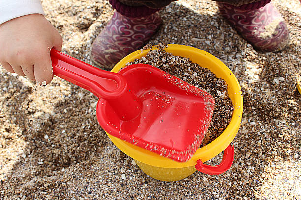 Child plays in the sand bucket and shovel stock photo