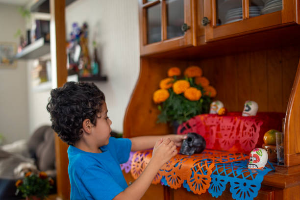 Child putting altar of the dead at home stock photo