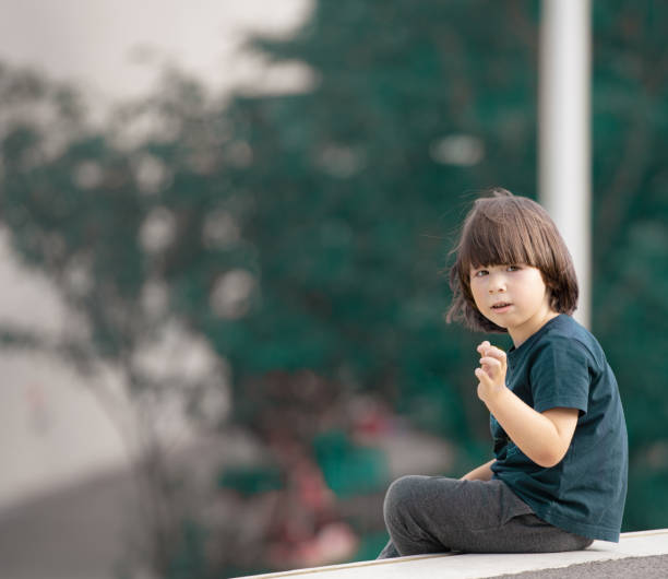 Child sits on the edge in the garden stock photo