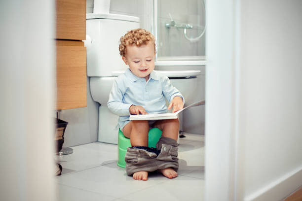 Child sitting on the toilet stock photo