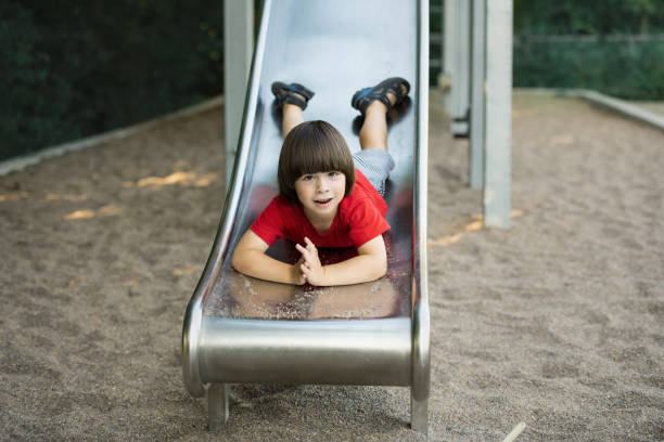 Child slides down on playground stock photo