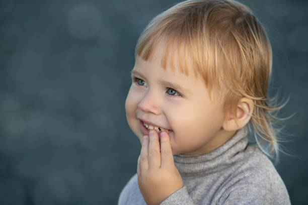 Child smiles face portrait on blue bokeh background stock photo