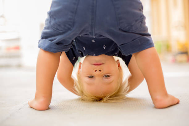 Child standing upside down, smiling happily stock photo