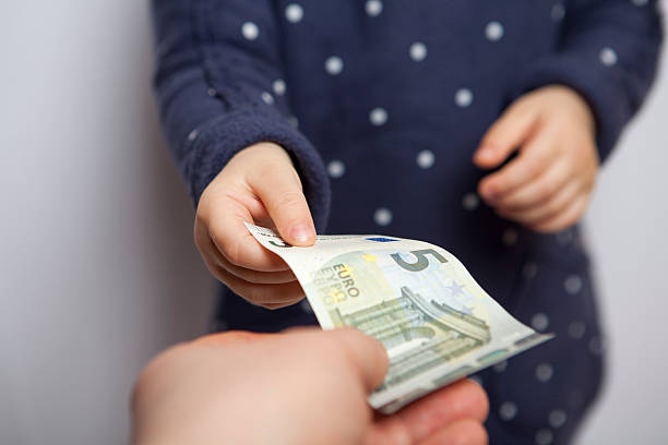 Child takes money Small child hand takes five euros banknote from adult hand allowance stock pictures, royalty-free photos & images