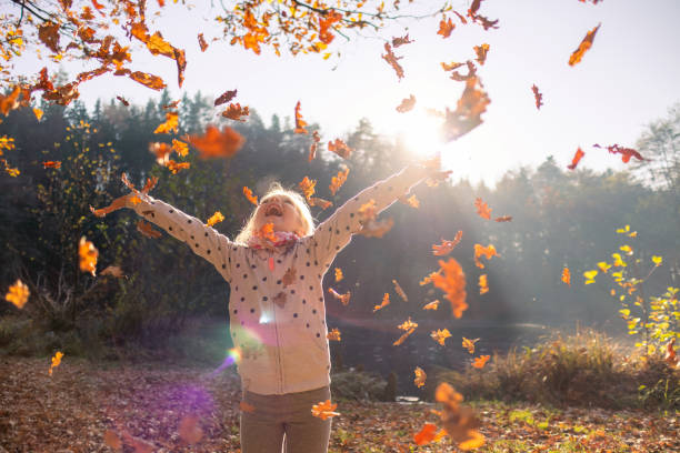 秋に乾いた葉を投げる子供 - 紅葉　子供 ストックフォトと画像