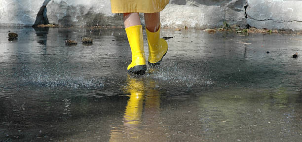 child walking in the rain stock photo