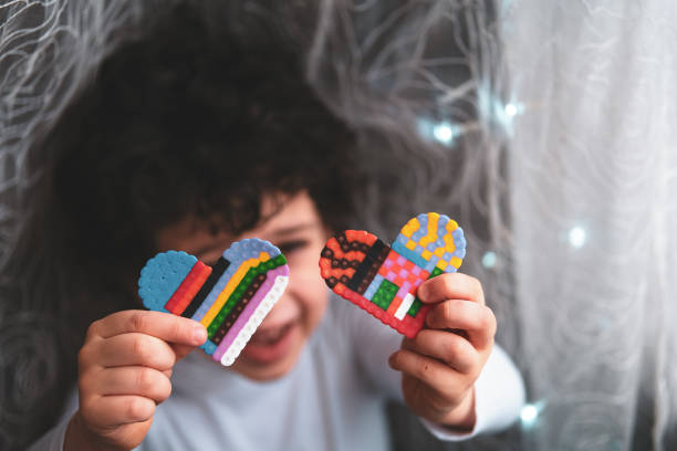 Child with hand made mosaic plastic hearts stock photo