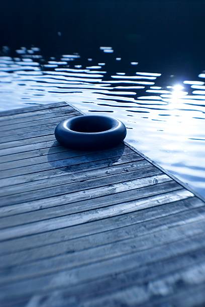 Childhood Memories : Inner tube on a peaceful dock at sunset. stock photo