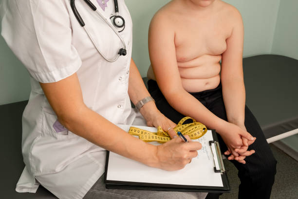 Childhood obesity problem. Fat boy at a nutritionist appointment. Childhood obesity problem and weight loss. Fat boy at a nutritionist appointment. Overweight boy consulting with doctor in office. Doctor examining fat boy in clinic. Doctor measuring overweight boy. obesity stock pictures, royalty-free photos & images