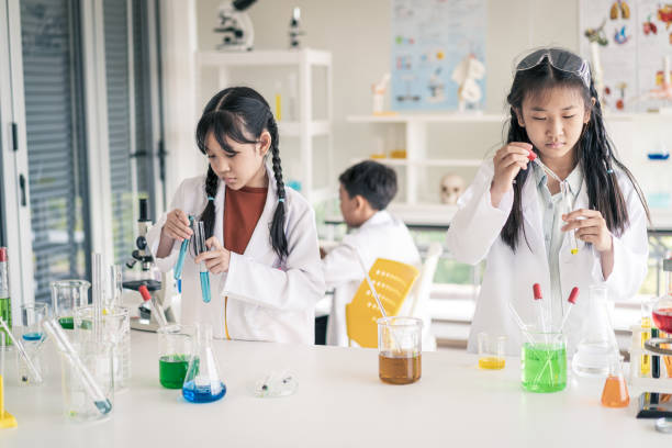 Childhood students and friends learning science in classroom lab Young Students and friends learning scientist in classroom lab with fun and happiness asian child scientist stock pictures, royalty-free photos & images
