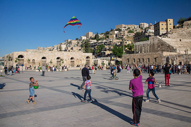 Children at play in front the historic Roman Theatre in Amman stock photo