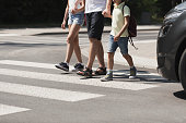 Children crossing the street with their father
