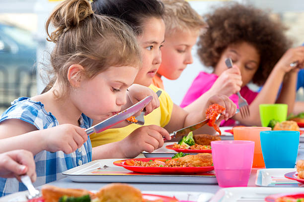 children eating school dinners - lunchroom stockfoto's en -beelden