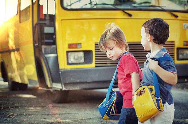 Children going to school 3-4 years-old children going to school with a school bus boarding schools stock pictures, royalty-free photos & images